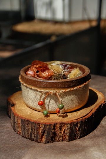 Aromatizador artesanal em pote de cerâmica sobre base de madeira